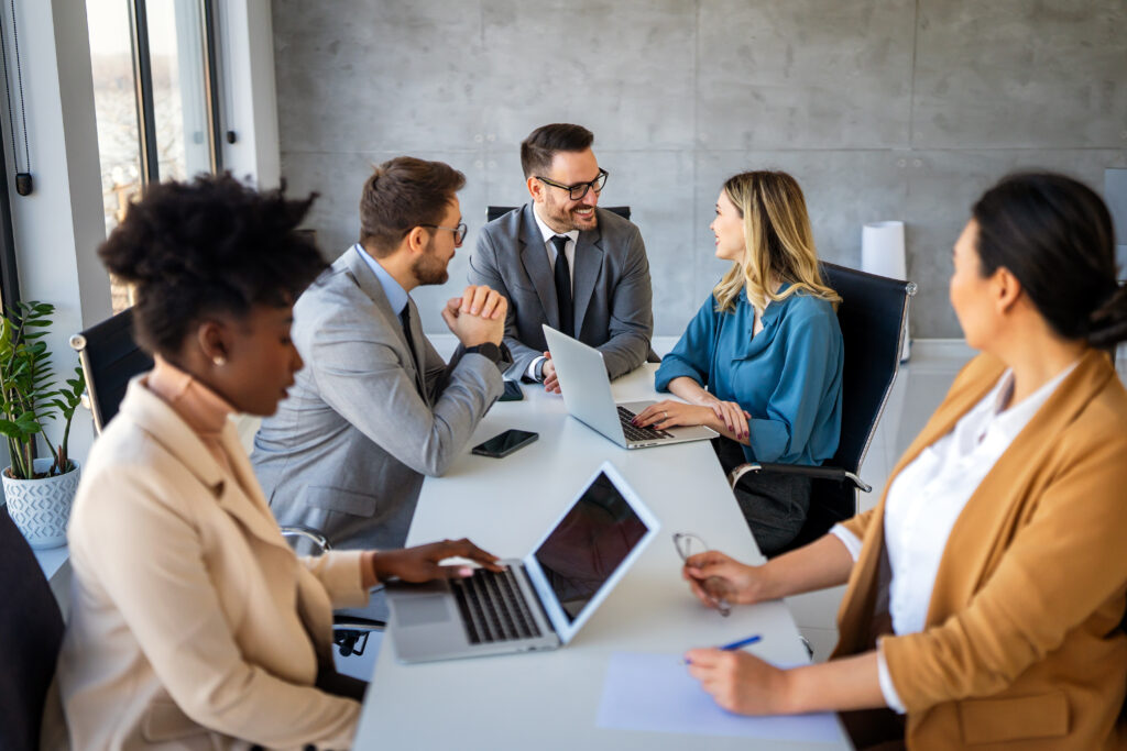 Group of multi-ethnic corporate business team collaborating on project in modern office. Diverse successful entrepreneurs working as a team together.